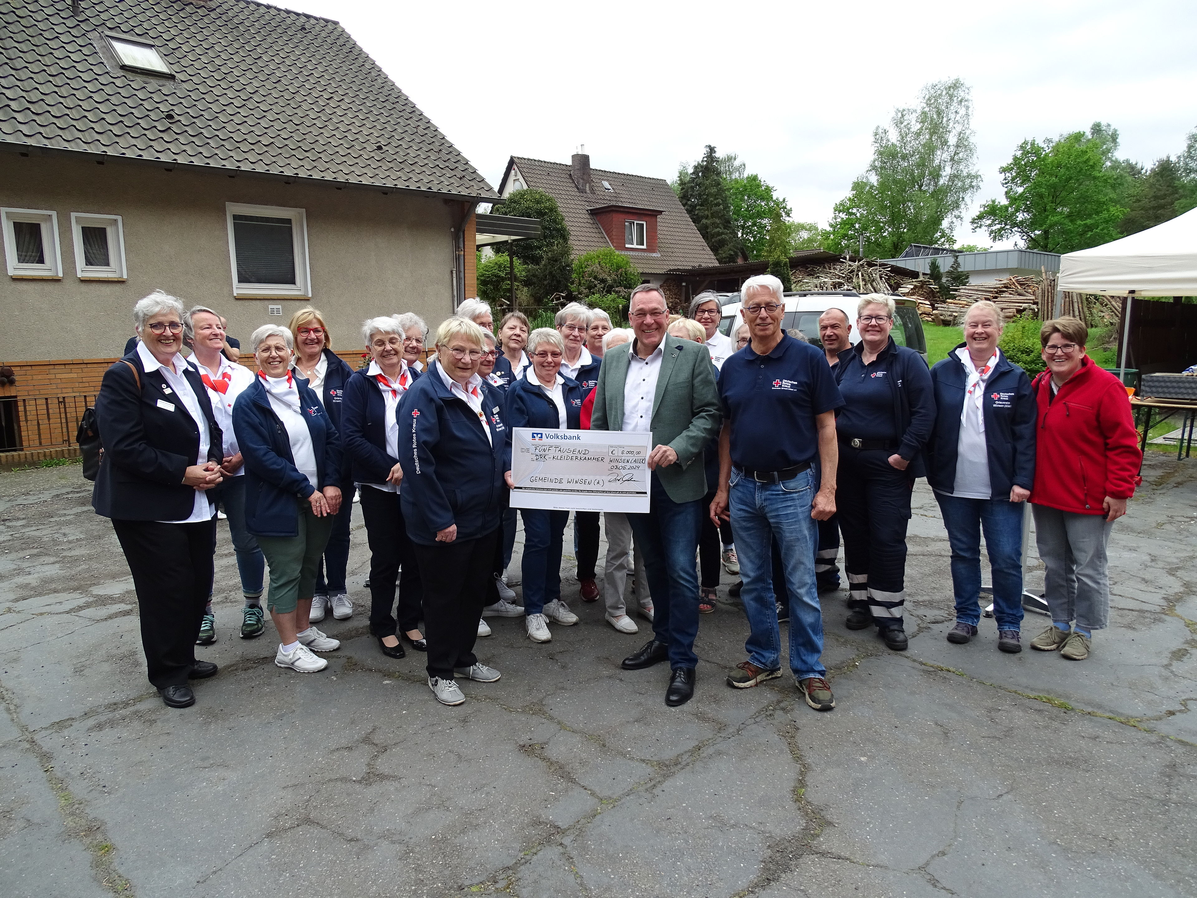 im Beisein des Vorstandes und der Aktiven des DRK-Ortsvereins überreicht Bürgermeister Oelmann den Scheck der Gemeinde Winsen (Aller) an Teamleiterin Kleiderkammer Frau de Schipper und Frau Meyer